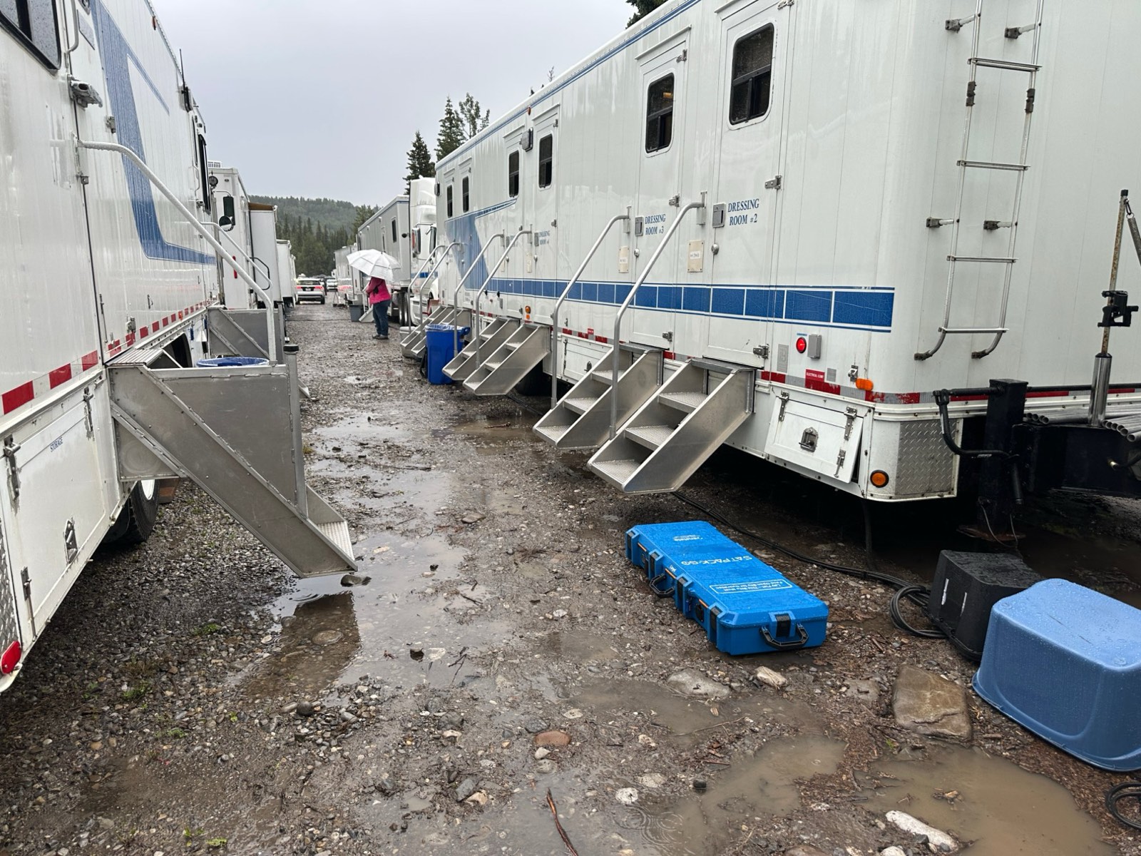 SatPack Pro units in a muddy basecamp trailer alley between dressing rooms